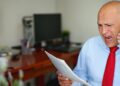 Man in blue shirt and red tie at office