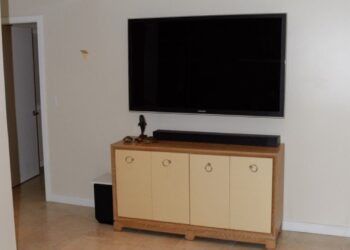 A modern flat-screen TV and soundbar in a living room, representing cable and streaming spending