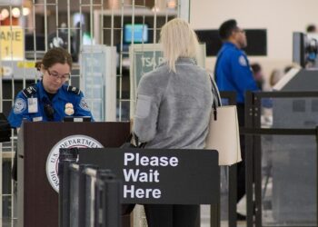 TSA officers staff a security checkpoint at an airport